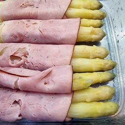 Je zwei Stangen Spargel werden mit einer Scheibe Schinken umwickelt.